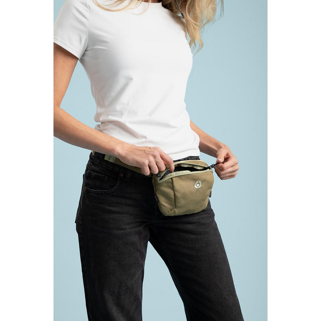 Person wearing a beige waist bag against a light blue background
