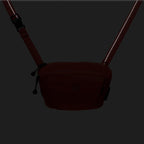 Dark brown crossbody bag on a black background