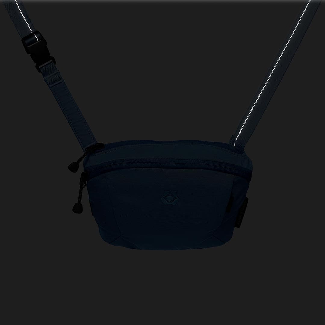 Black waist bag with a strap on a dark background