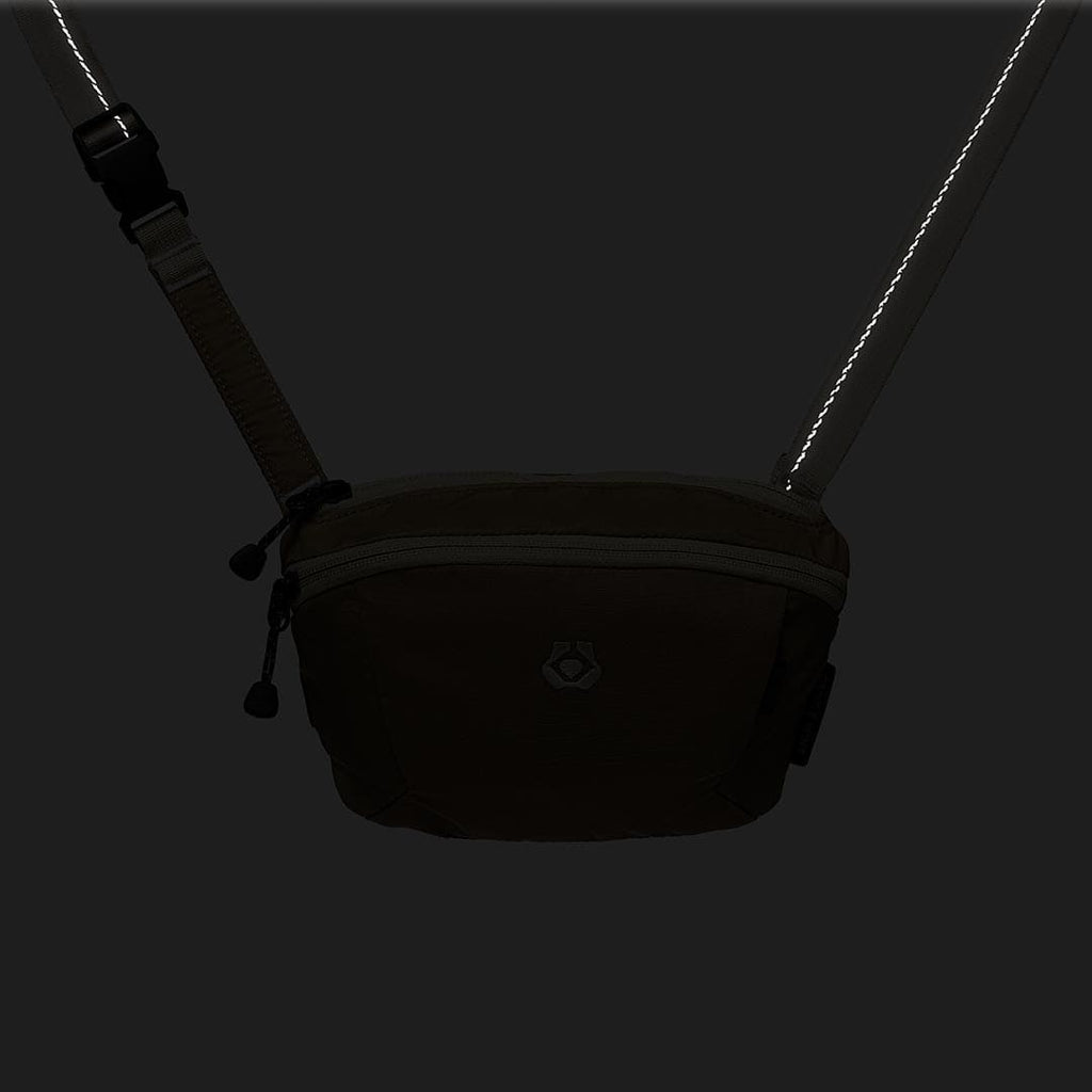 Black waist bag with a strap on a black background