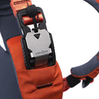 Close-up of an orange strap with a Fidlock lock mechanism on a blurred background