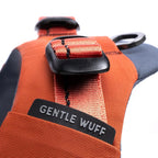 Orange dog harness with 'GENTLE WUFF' label on a white background