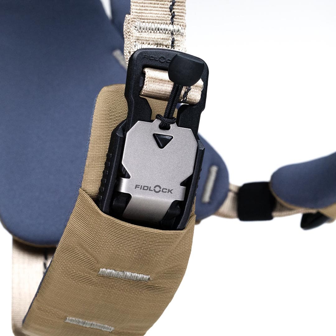 Close-up of a Fidlock lock mechanism on a strap with a beige pouch.