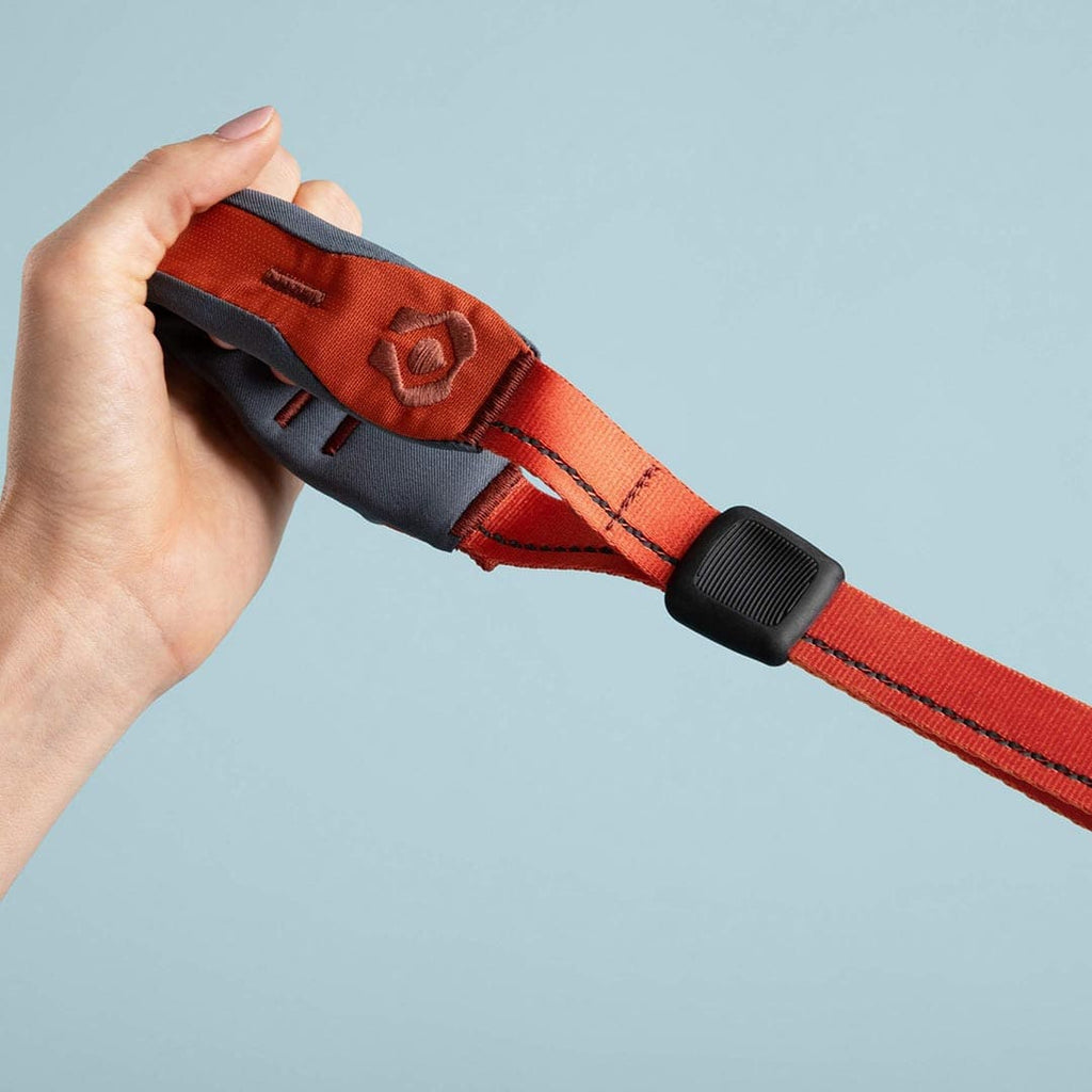 Hand holding a red quick grip against a light blue background
