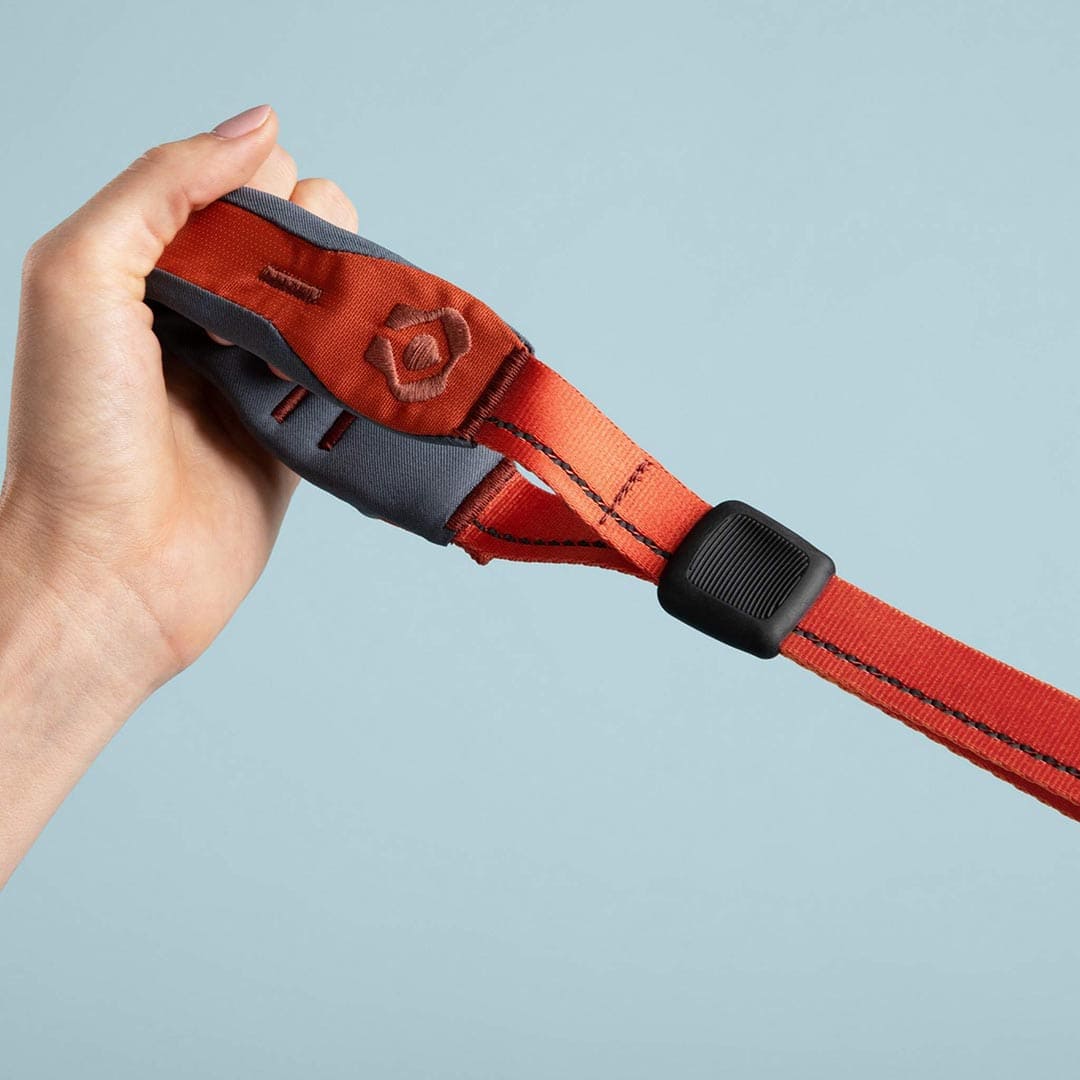 Hand holding a red quick grip against a light blue background