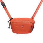 Orange crossbody bag with a visible brand logo on a white background