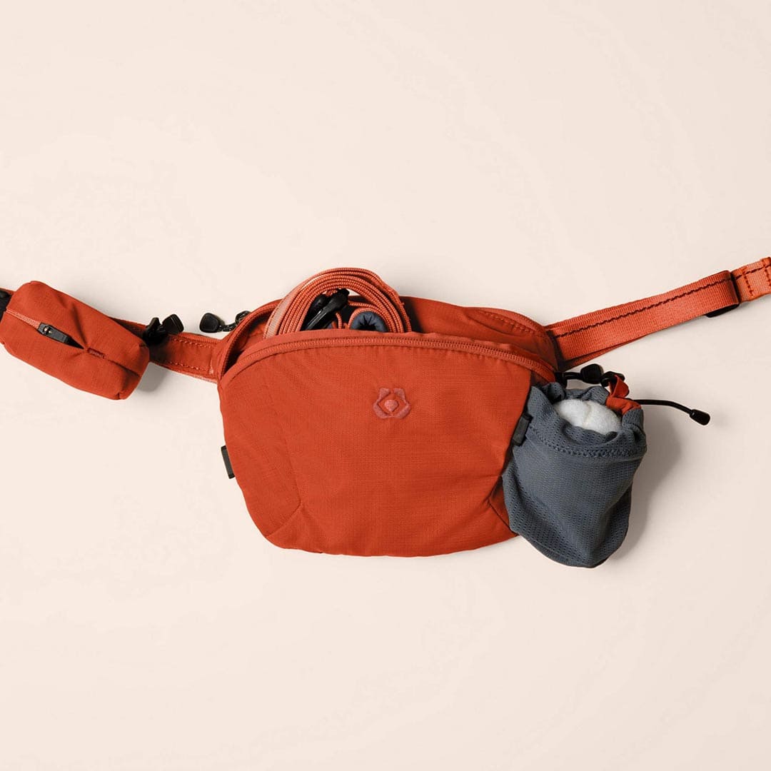 Orange waist bag with a small gray pouch on a beige background