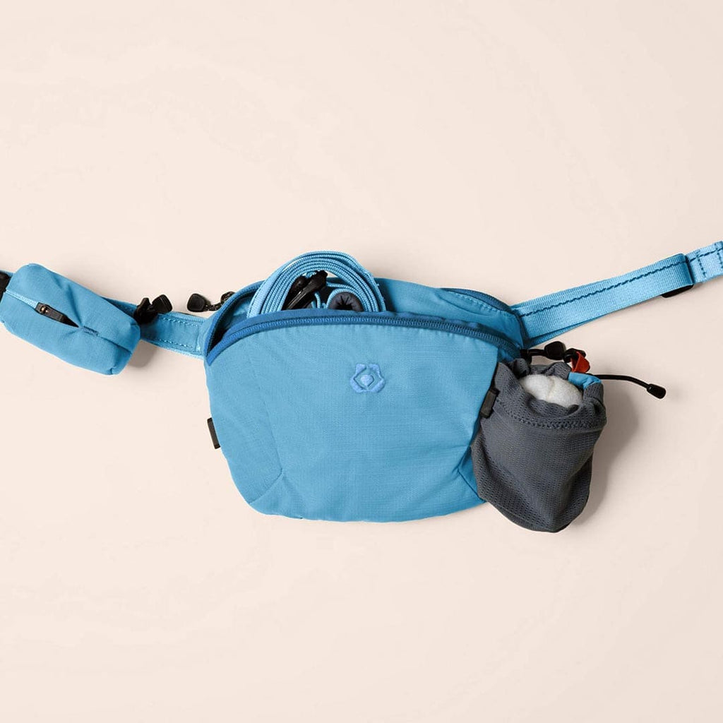 Blue waist bag with a small gray pouch on a beige background