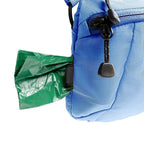 Blue backpack with a green trash bag attached to it on a white background