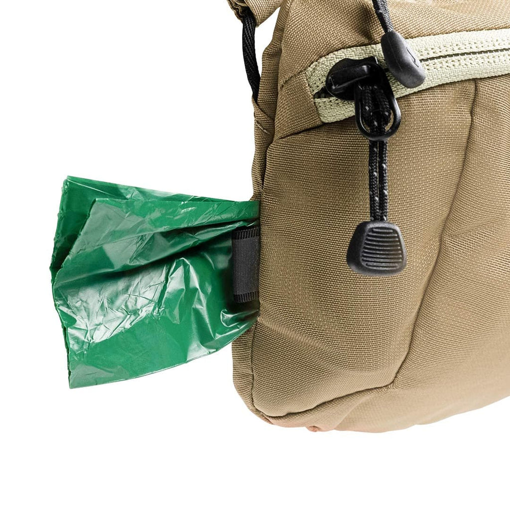 Beige bag with a green trash bag attached to it on a white background